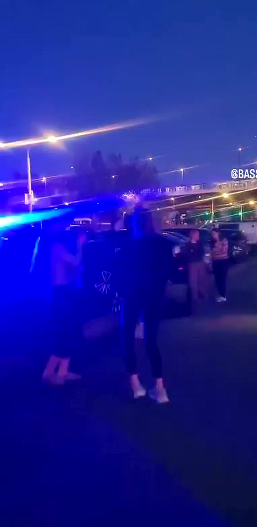Menschen tanzen bei blauem Licht am Rheinufer
