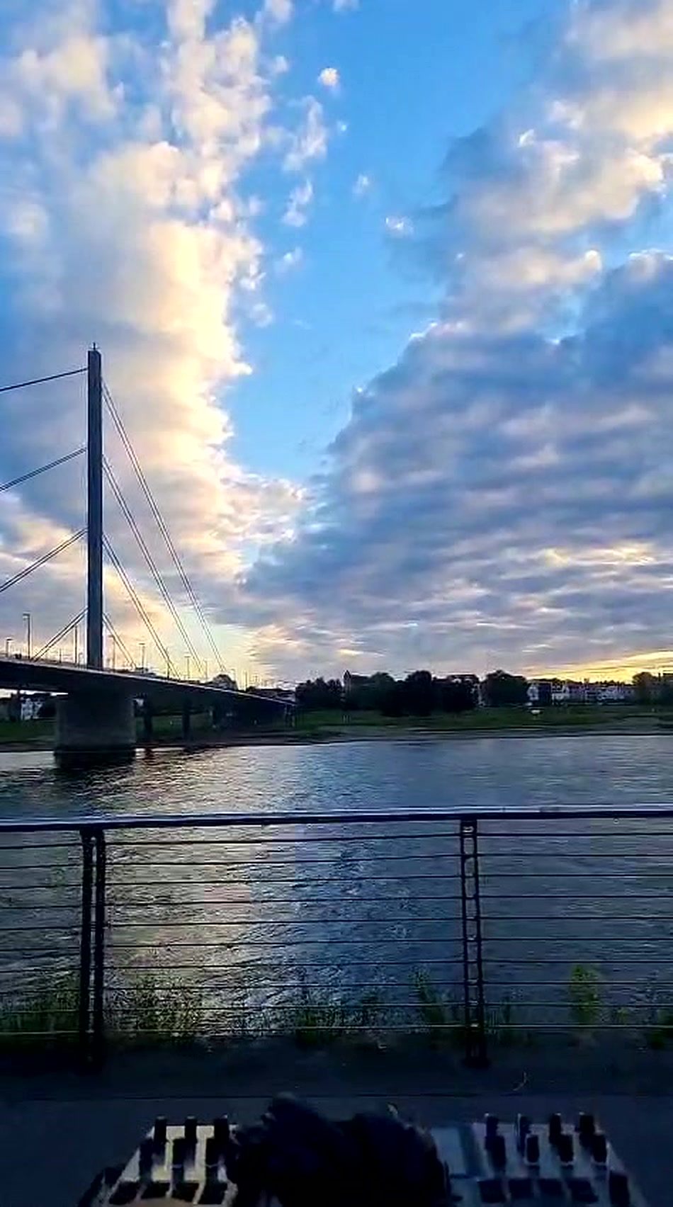 Dramatischer Abendhimmel über dem Rhein mit Brücke